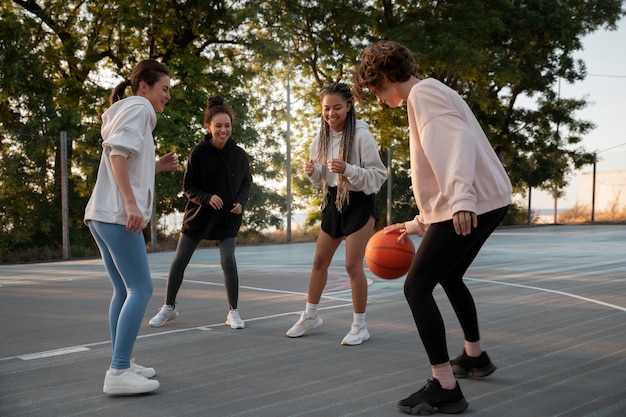 Free photo full shot women playing basketball