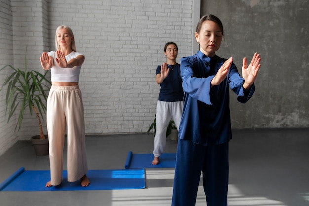 Donne a figura intera che praticano insieme il tai chi