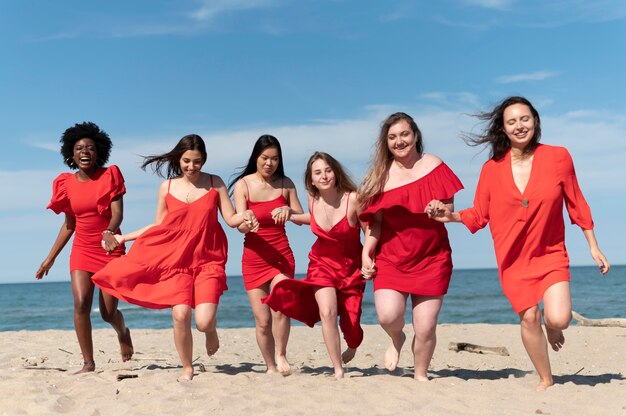 Full shot women running on beach