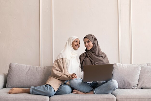 Full shot women sitting on couch