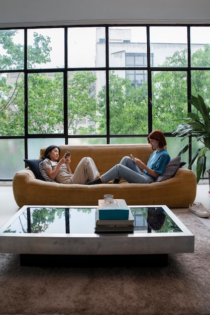 Full shot women sitting on couch