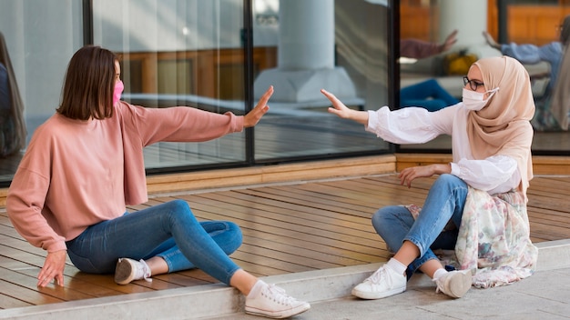 Full shot women sitting at distance