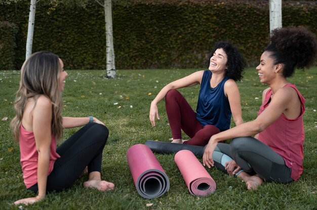 Free photo full shot women sitting on grass