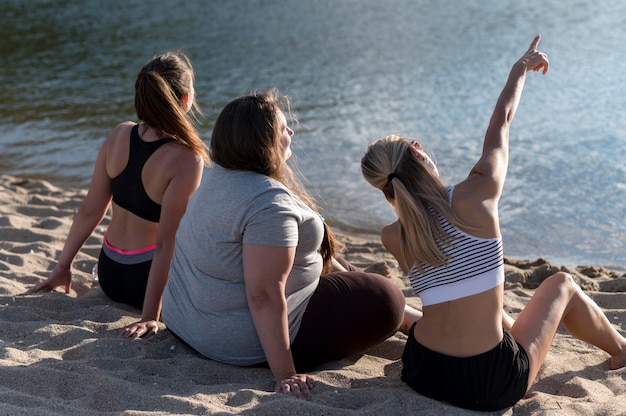 Full shot women sitting on shore