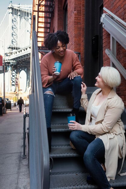 Full shot women sitting on stairs