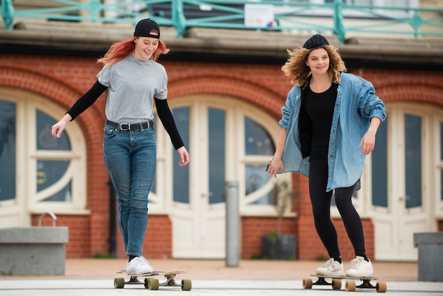 Free photo full shot women on skateboards