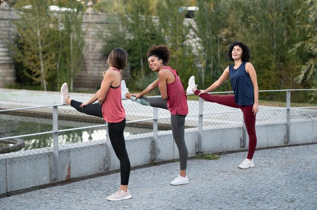 Full shot women stretching in nature