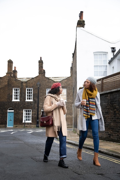 Free photo full shot women walking with coffee