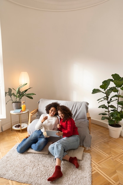 Full Shot Women Watching Movie On Tablet