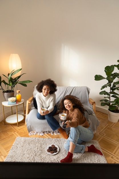 Foto gratuita donne a tutto campo che guardano la tv insieme