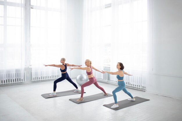 Full shot women on yoga mat