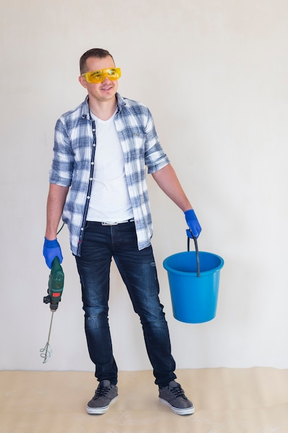 Free photo full shot of worker holding a bucket