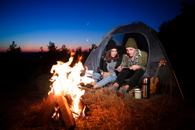 Free photo full shot young couple with bonfire