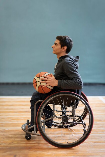 Полный выстрел молодой инвалид, держащий баскетбол