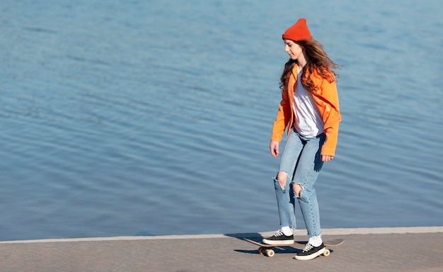 Full shot young girl on skate by the lake