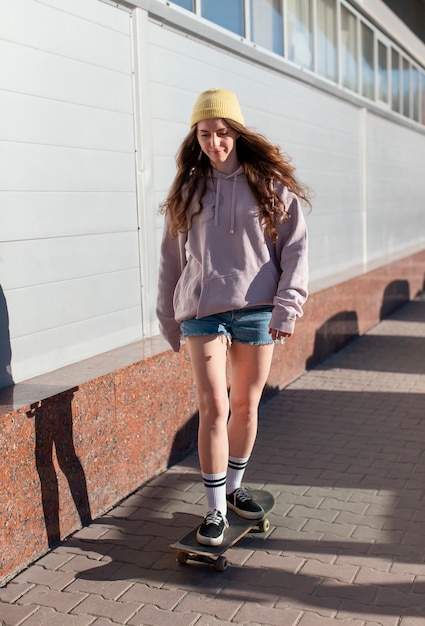無料写真 外でスケートをするフルショットの若い女の子