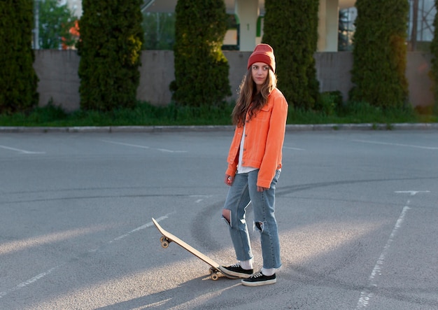 Free photo full shot young girl with skateboard outdoors