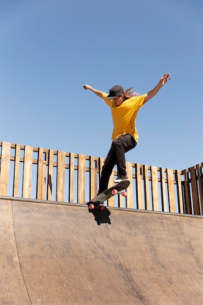 Full shot young man doing tricks on skateboard