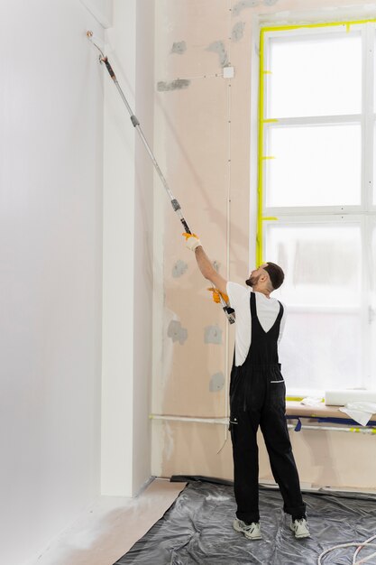 Full shot young man painting wall