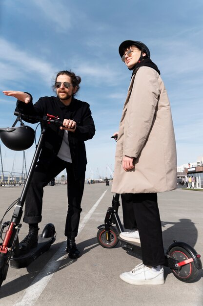 Full shot young men with electric scooters