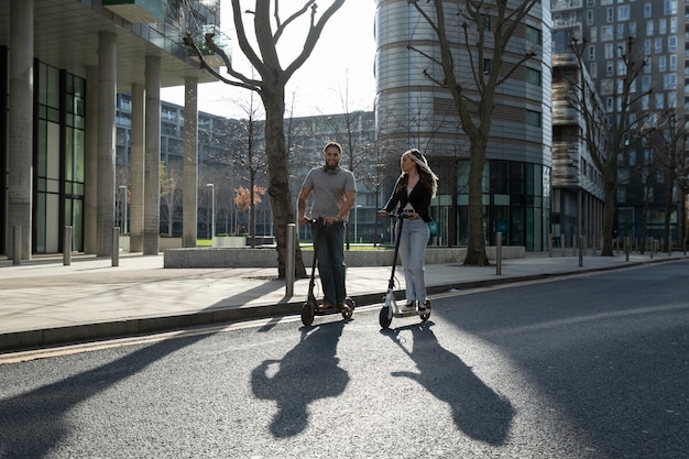 Foto gratuita giovani a tutto campo su scooter elettrici