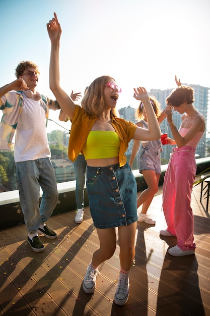 무료 사진 옥상에서 파티를 하는 풀샷 젊은이들