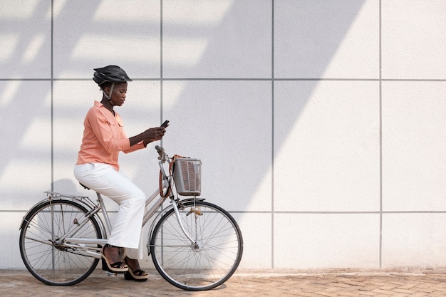 Free photo full shot young woman on bicycle