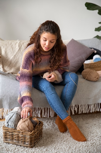 フルショットの若い女性の編み物