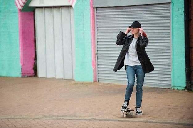 Полный снимок молодой женщины на скейтборде