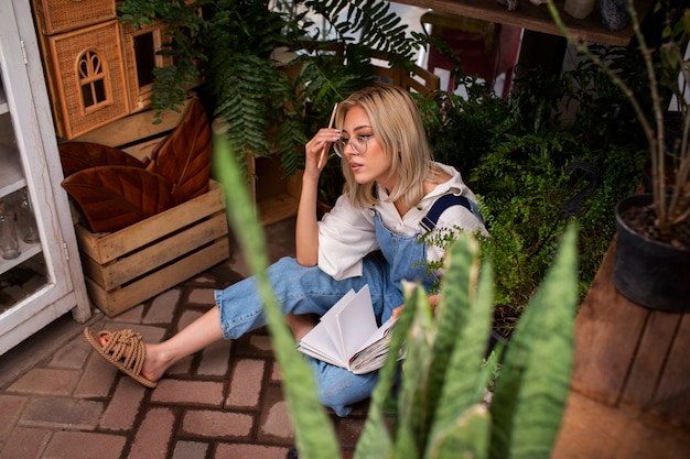 Free photo full shot young woman surrounded by plants