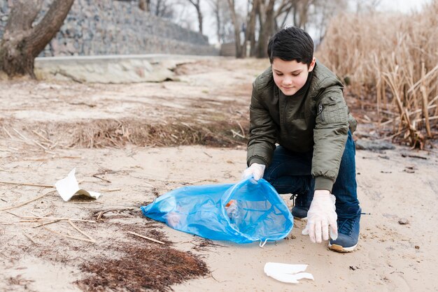 Full view of boy cleaning the ground