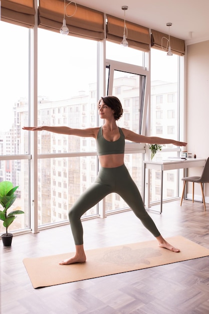 Foto gratuita punto di vista completo della donna caucasica che resta sulla posa di yoga