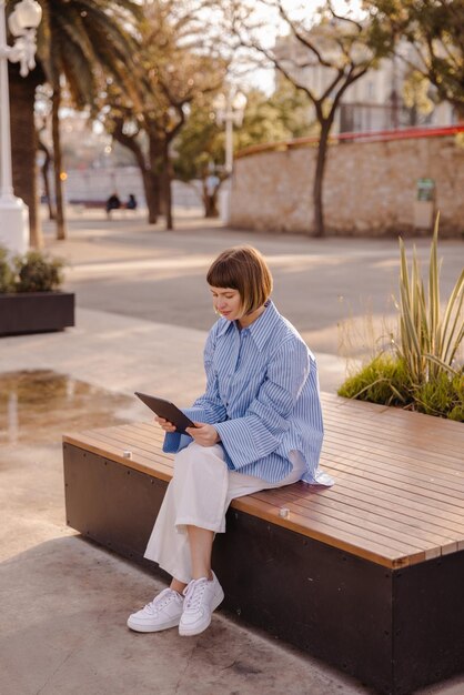 Full view of cute woman looking at tablet