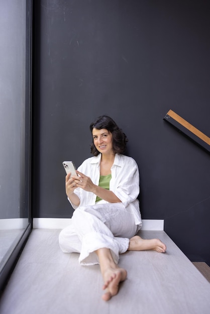 Full view of female woman with phone smiles at camera