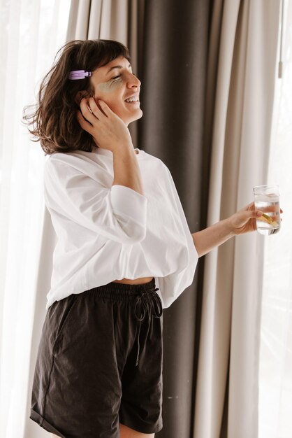 Full view of happy woman with green patches at home