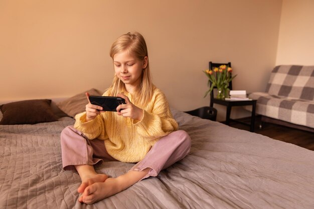 Full view of little cute girl holding phone