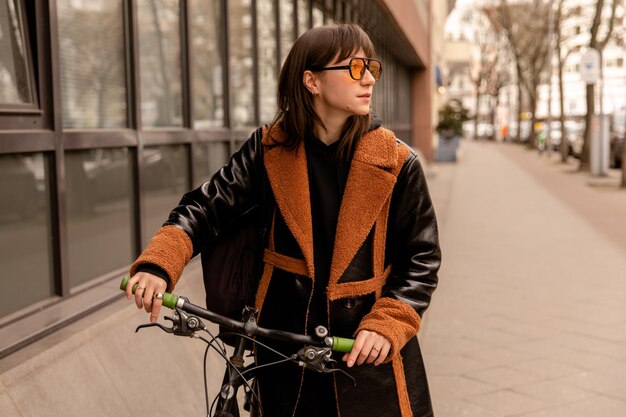 Full view of woman in yellow sunglasses with bike