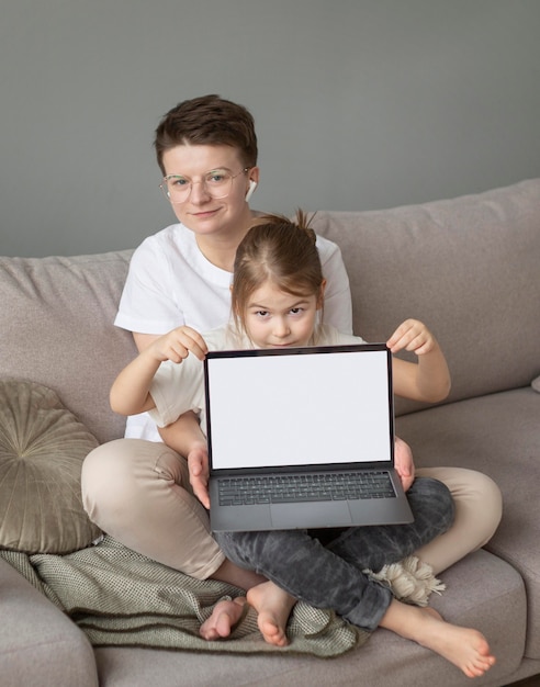 Fulls shot parent and kid on couch with laptop