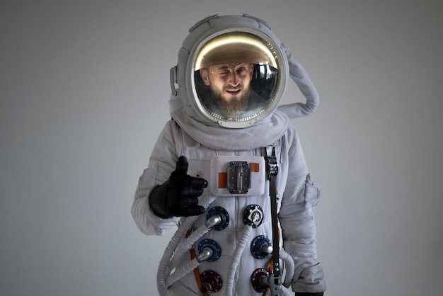 Полностью экипированный мужчина-космонавт показывает палец вверх