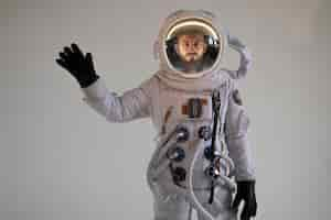 Free photo fully equipped male astronaut waving in his spacesuit