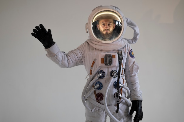 그의 우주복을 흔들며 완벽한 장비를 갖춘 남성 우주 비행사