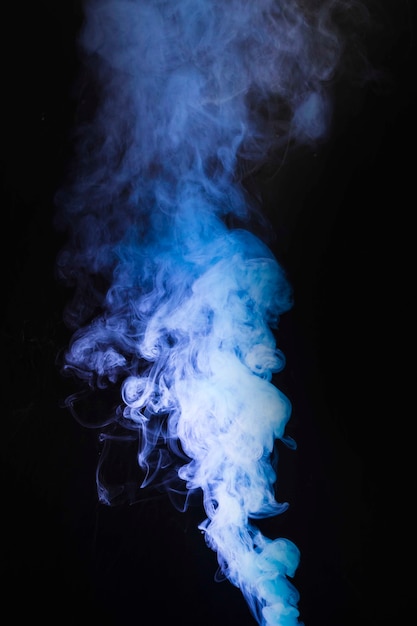 Free photo fumes of purple smoke at the center of the black backdrop