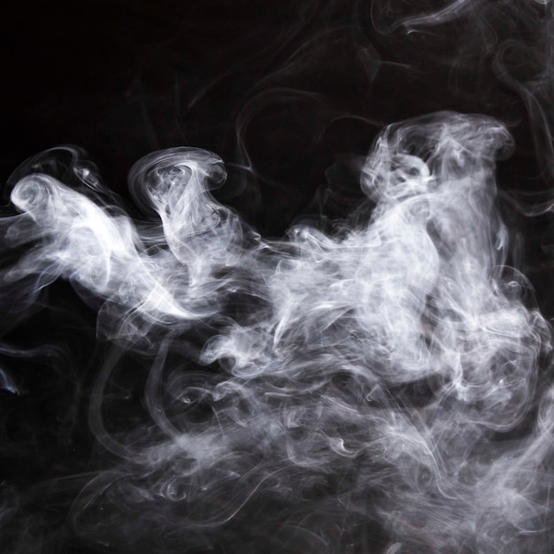 Free photo fumes of smoke spread over the black backdrop