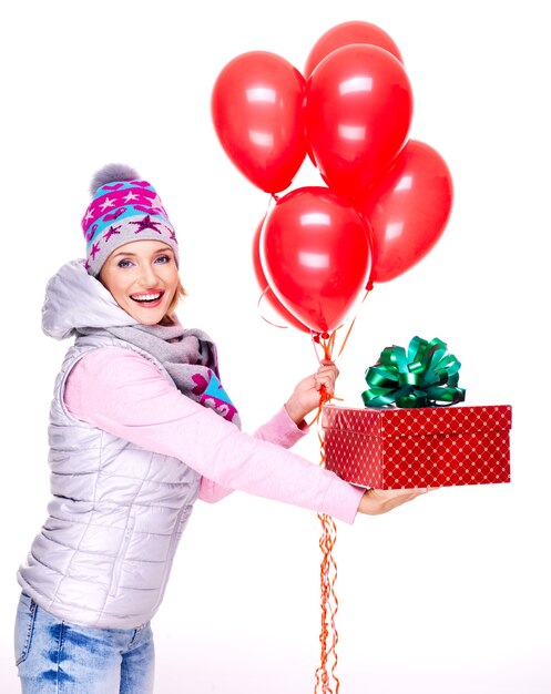 Fun happy adult woman gives the red gift box isolated on white