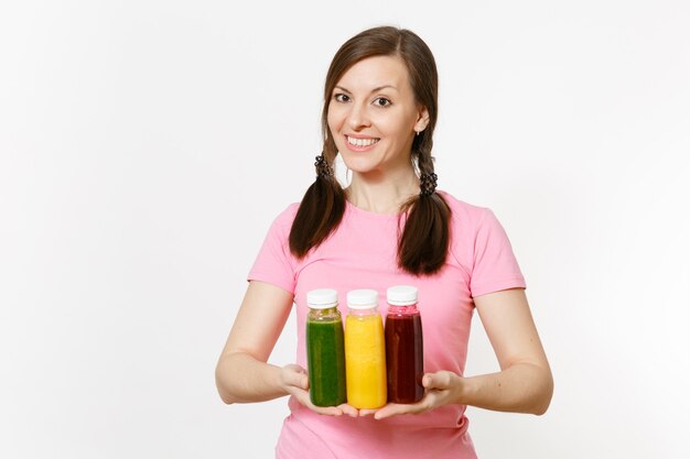 재미있는 여자는 흰색 배경에 격리된 병에 녹색, 빨간색, 노란색 해독 스무디를 들고 있습니다. 적절한 영양, 채식 음료, 건강한 생활 방식, 다이어트 개념. 광고 공간을 복사합니다.