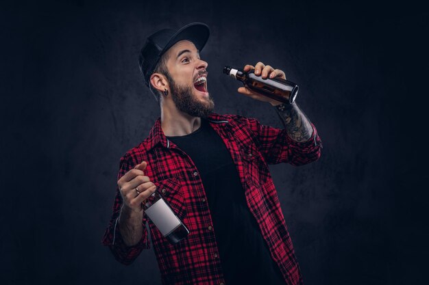 Funny bearded drunk hipster guy holds a beer bottle.