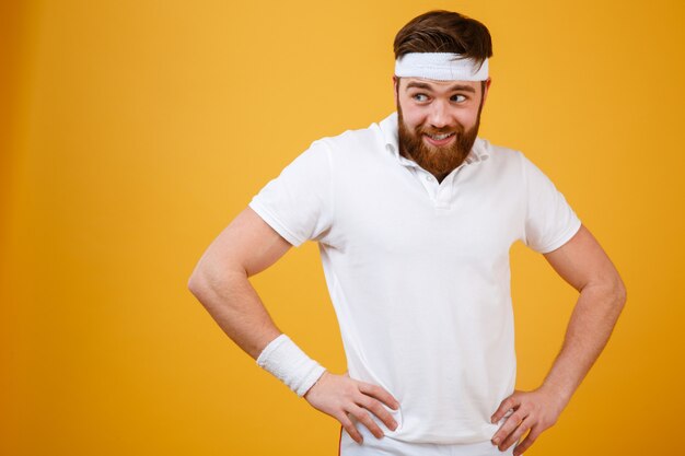 Funny bearded sportsman holding arms at hip