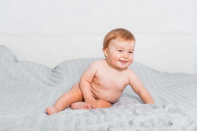 Funny blonde baby on a bed