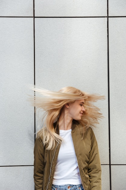 Foto gratuita donna bionda divertente che scuote i suoi capelli