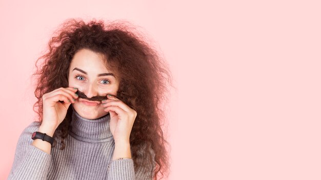 Funny brunette girl portrait on pink background